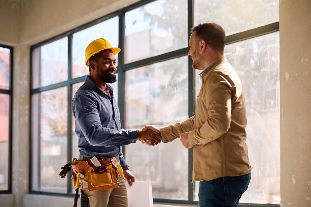 Happy customer shaking hands with professional repairman